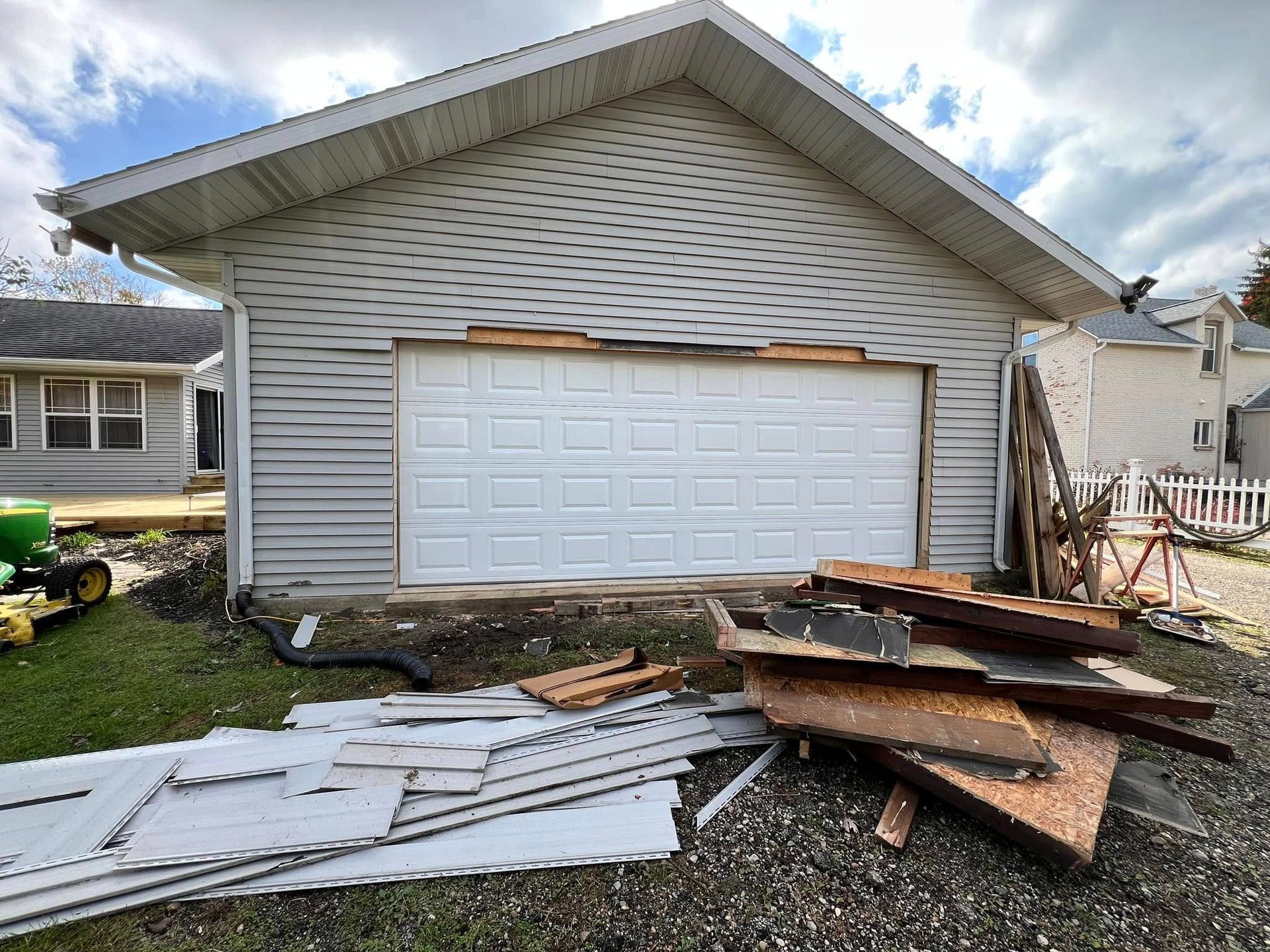 A garage door is being removed from a house.
