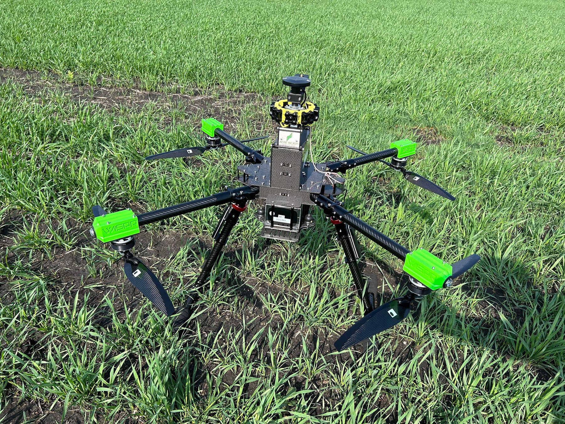 A drone is sitting on top of a lush green field.