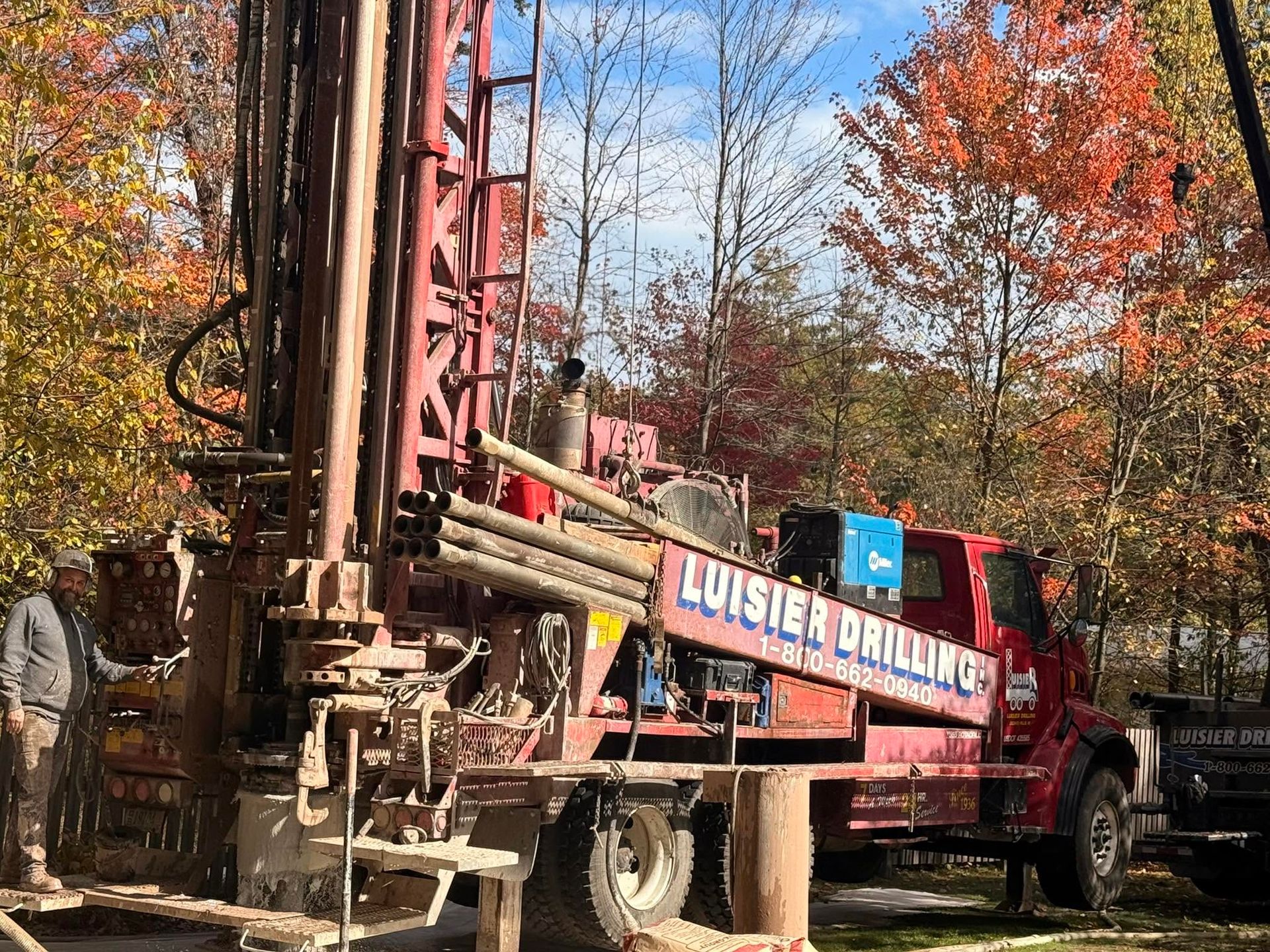 Drilling rig truck in autumn woods with red frame and blue 