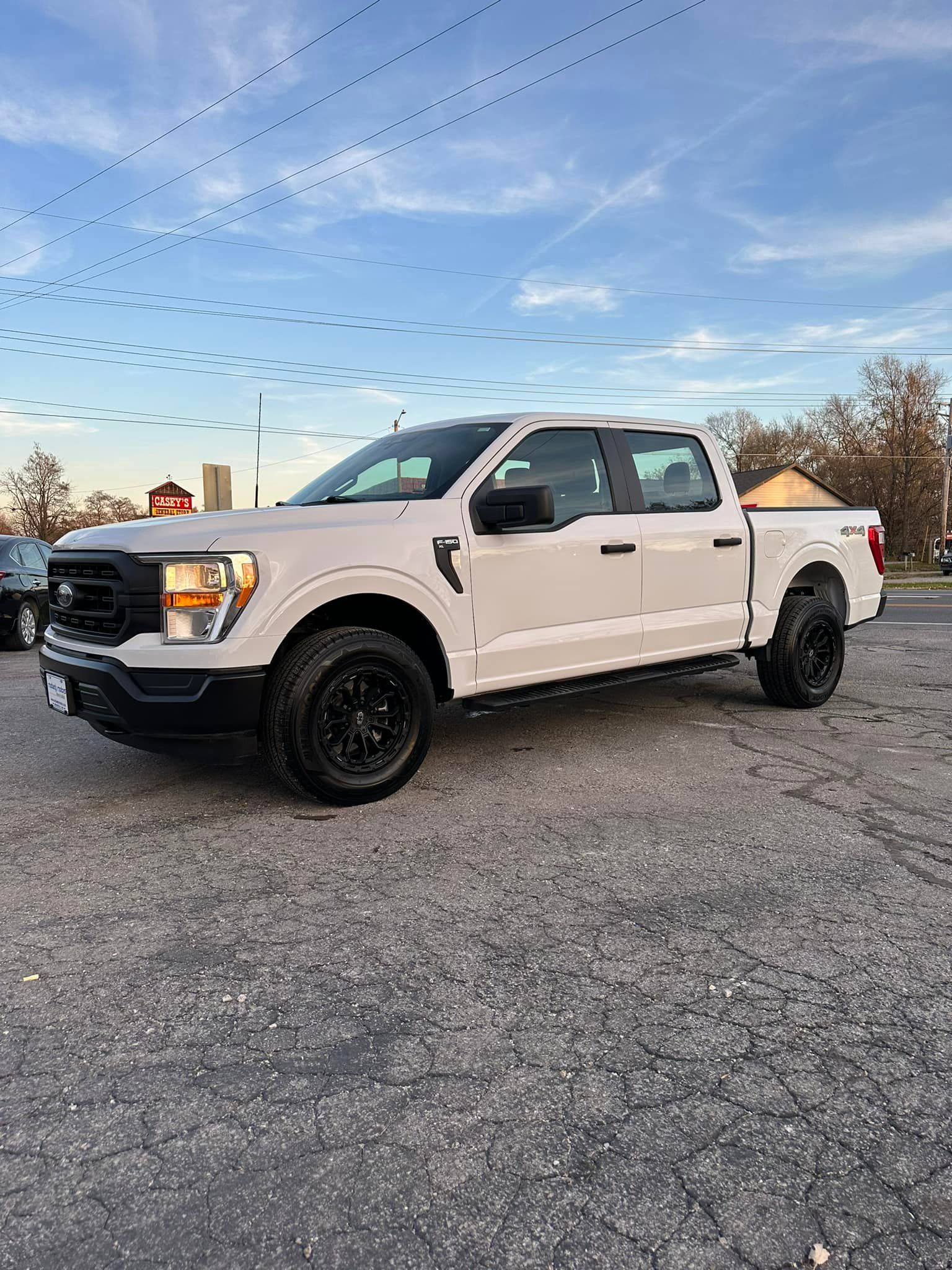 A white pickup truck is parked in a parking lot.