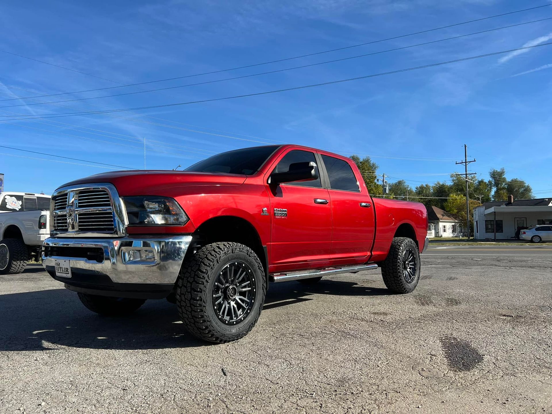 A red dodge ram truck is parked in a gravel lot.