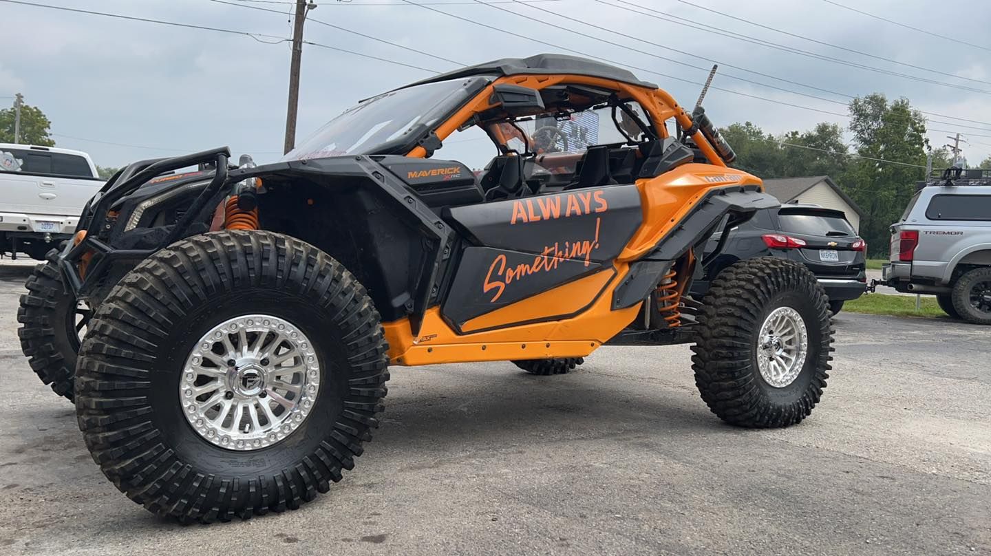 A yellow and black atv is parked in a parking lot.