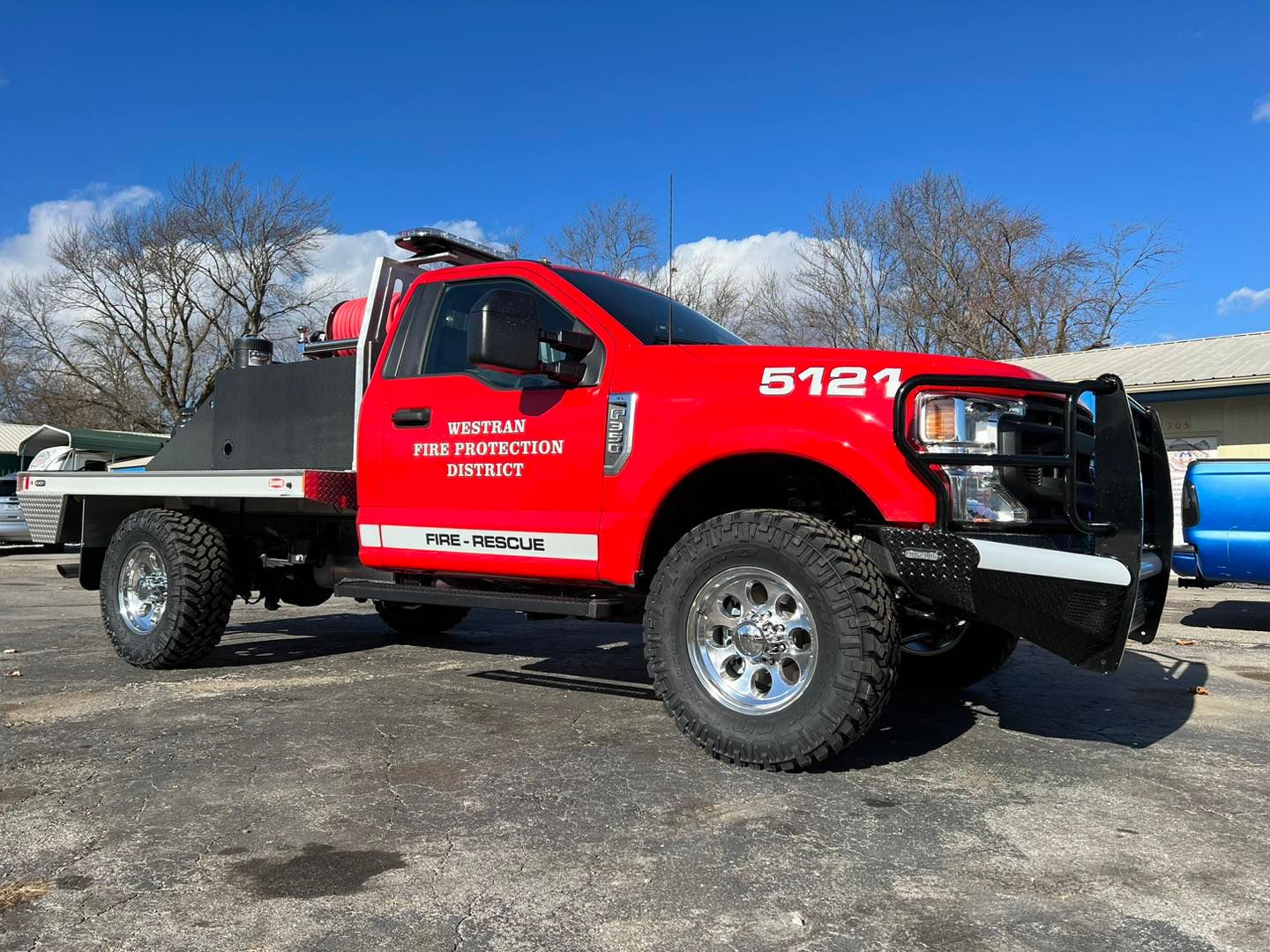 A red truck with the number 5121 on the side is parked in a parking lot.