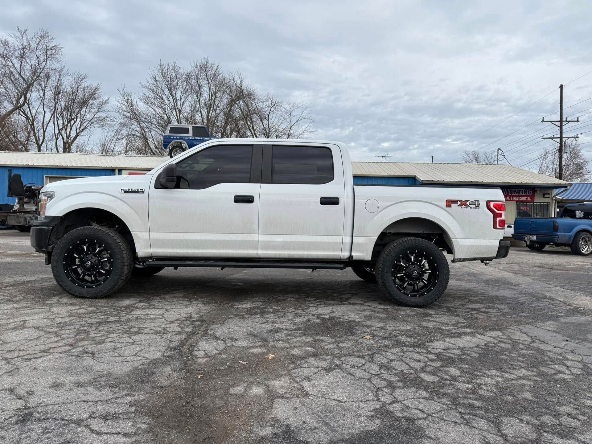 A white ford f150 truck is parked in a parking lot.