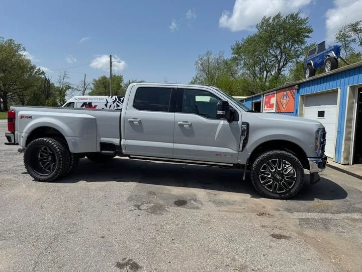 A silver truck is parked in front of a garage.