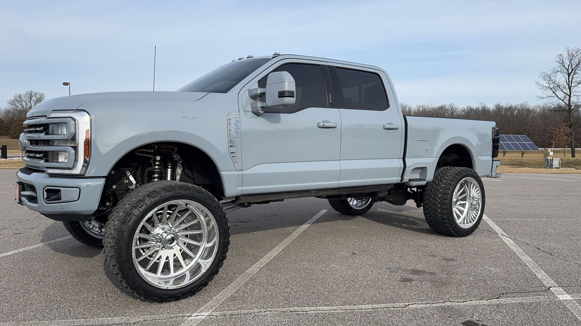 A gray truck is parked in a parking lot.
