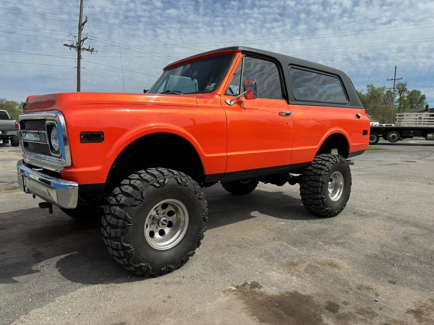 An orange chevrolet blazer is parked in a parking lot.