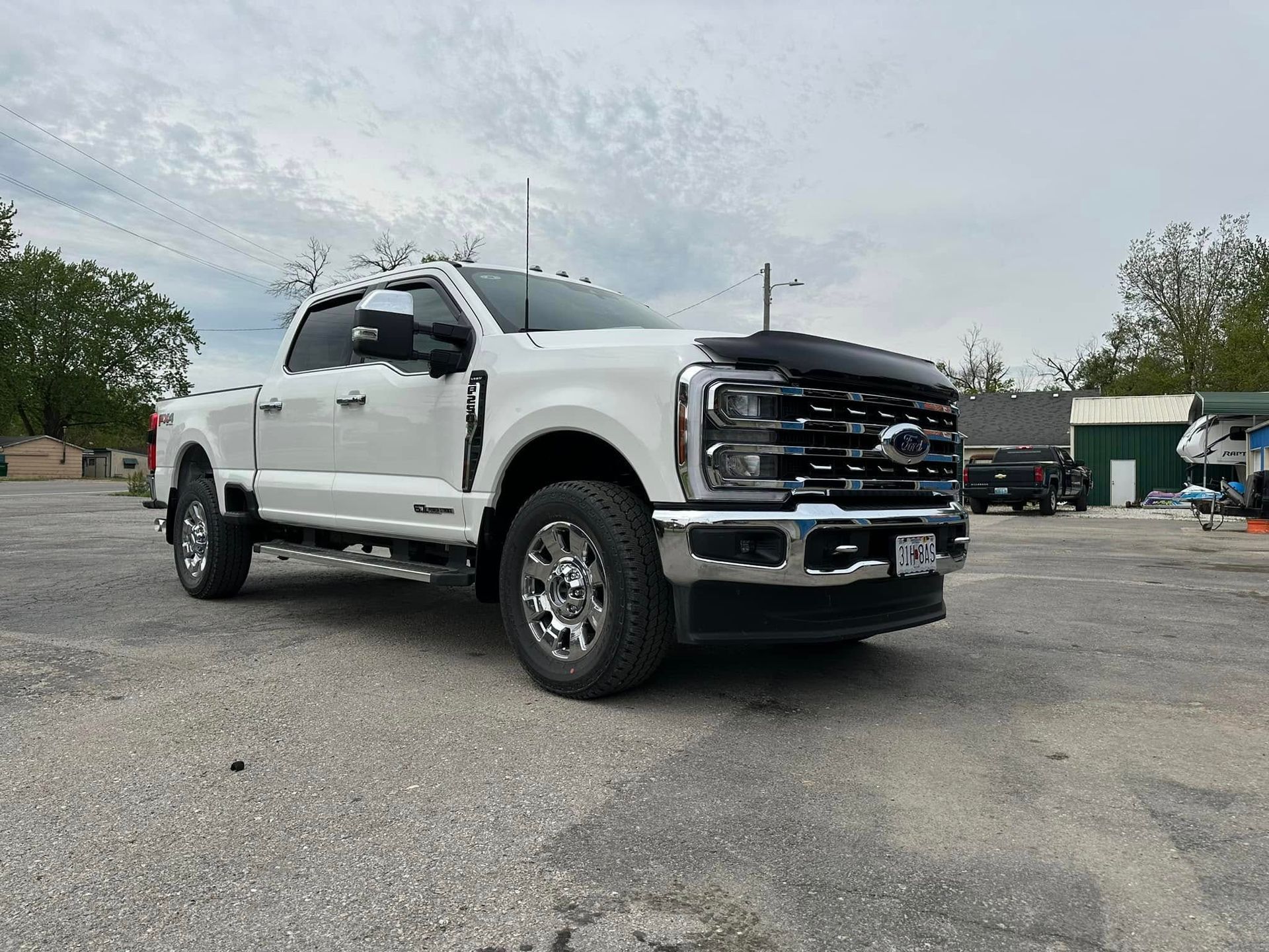 A white ford truck is parked in a parking lot.