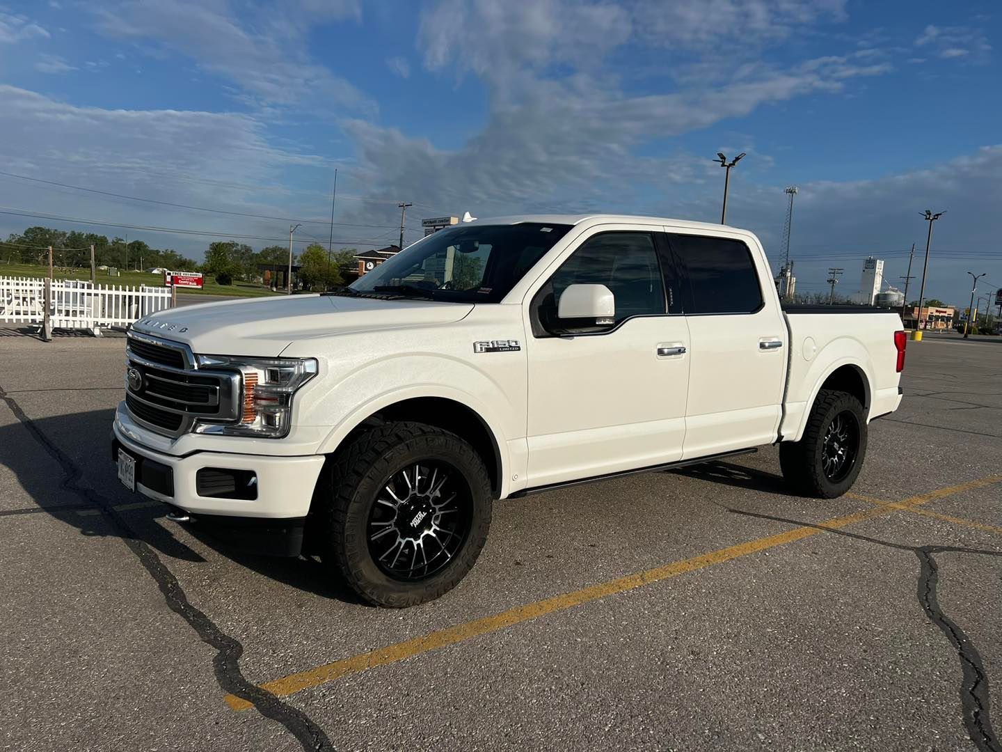 A white pickup truck is parked in a parking lot.