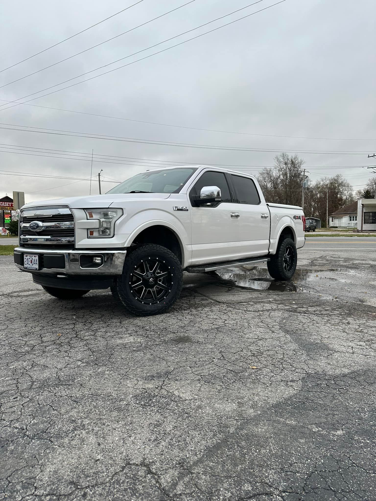 A white ford f150 truck is parked in a parking lot.