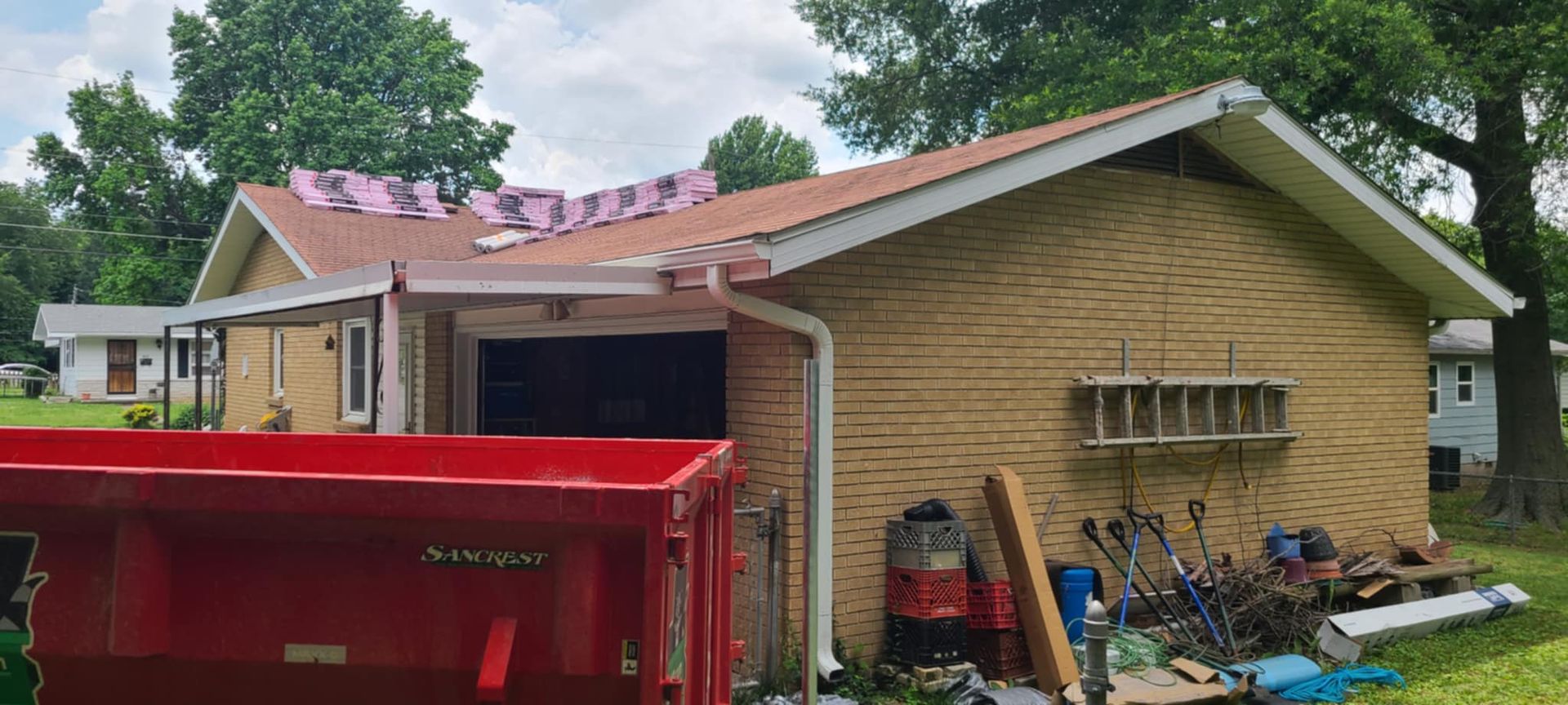 A house with a red dumpster in front of it.