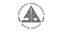 Monmouth-Ocean County Dental Society logo with a tree, tooth, and sea, in black and gray