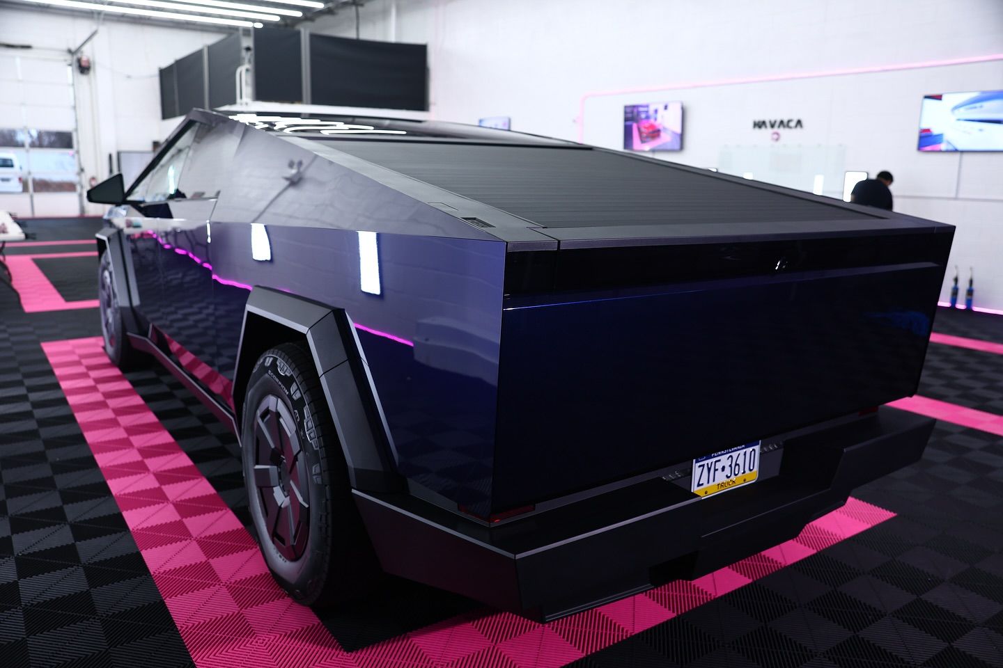 Tesla Cybertruck in a showroom with black and pink accents.