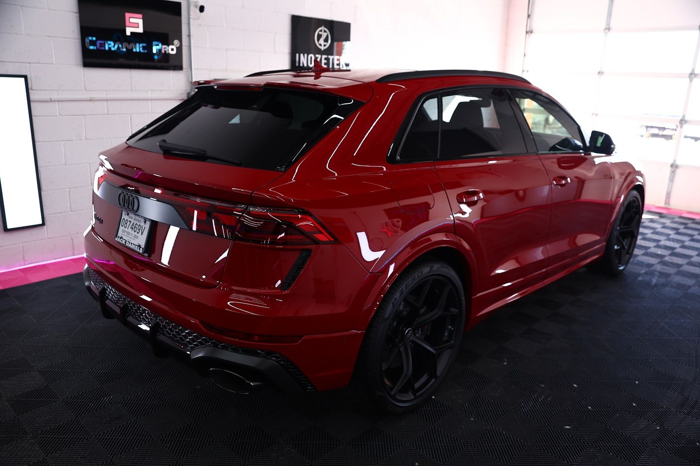 Red SUV parked inside a garage with black wheels and tinted windows.