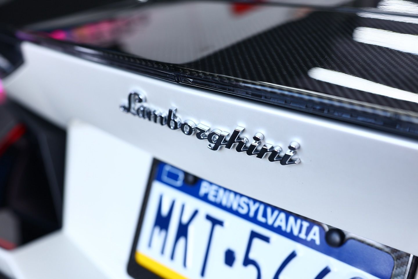 Lamborghini emblem on a white car with a Pennsylvania license plate.