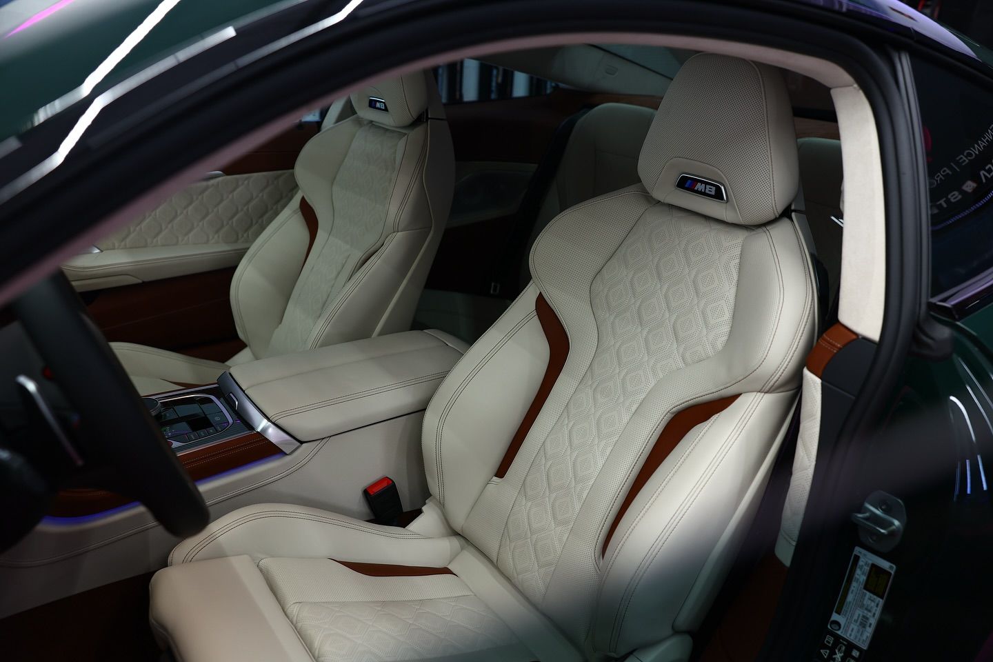 Cream leather car seats with brown accents and stitching, in a luxury vehicle interior.