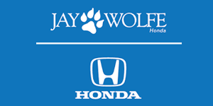 Logo for Jay Wolfe Honda. Text and paw print over a horizontal line, Honda logo below. Blue background.