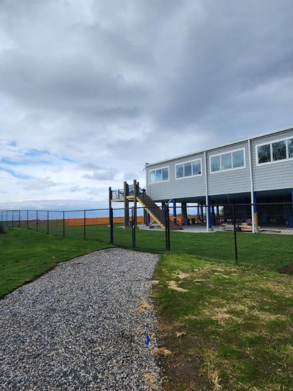 A house on stilts with a walkway leading to it.