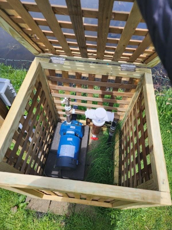 A wooden box with a water pump inside of it.