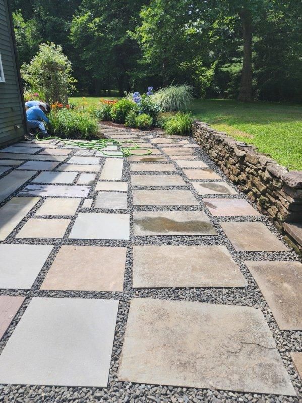 A stone walkway leading to a lush green yard