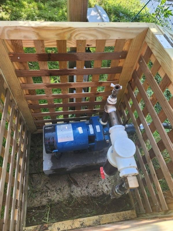 A blue water pump is sitting inside of a wooden box.