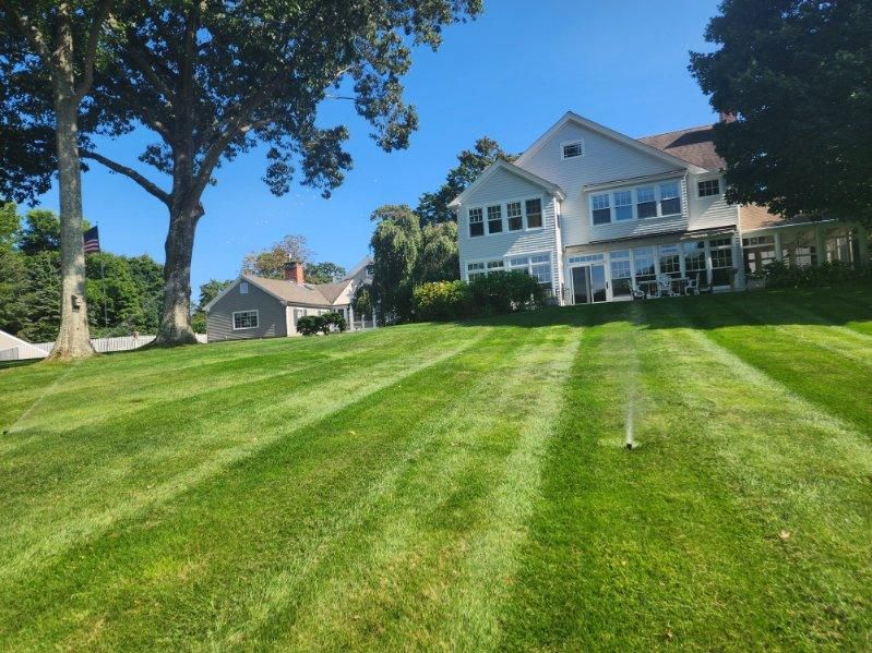 A large white house with a lush green lawn in front of it.