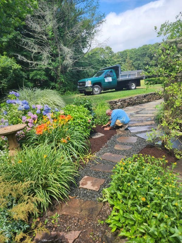 A man is working in a garden next to a truck.