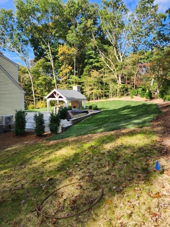A large lawn with a house and trees in the background.