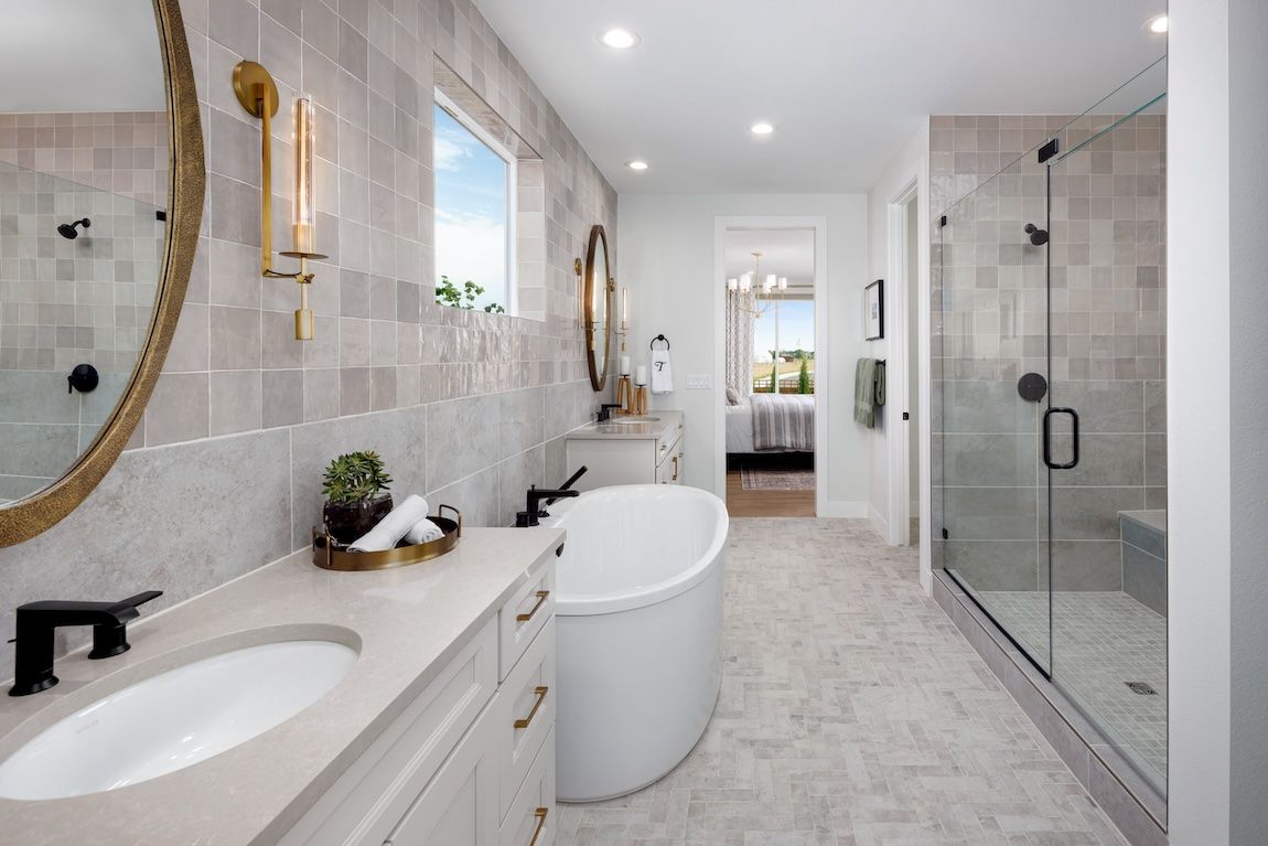 Spacious modern bathroom with double vanity, freestanding tub, glass shower, and neutral tones.