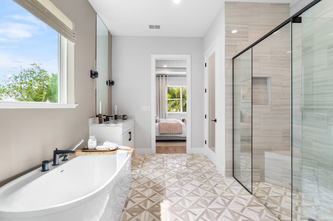 Bathroom with soaking tub, walk-in shower, patterned tile floor, and a window with a view.
