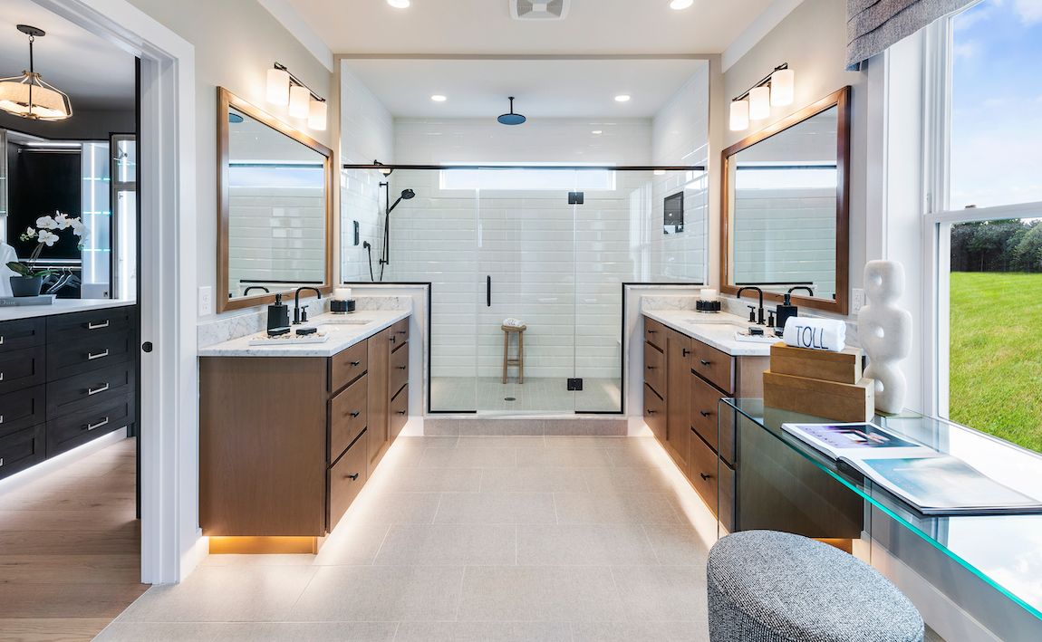Luxury bathroom with dual vanities, large shower, and natural light.