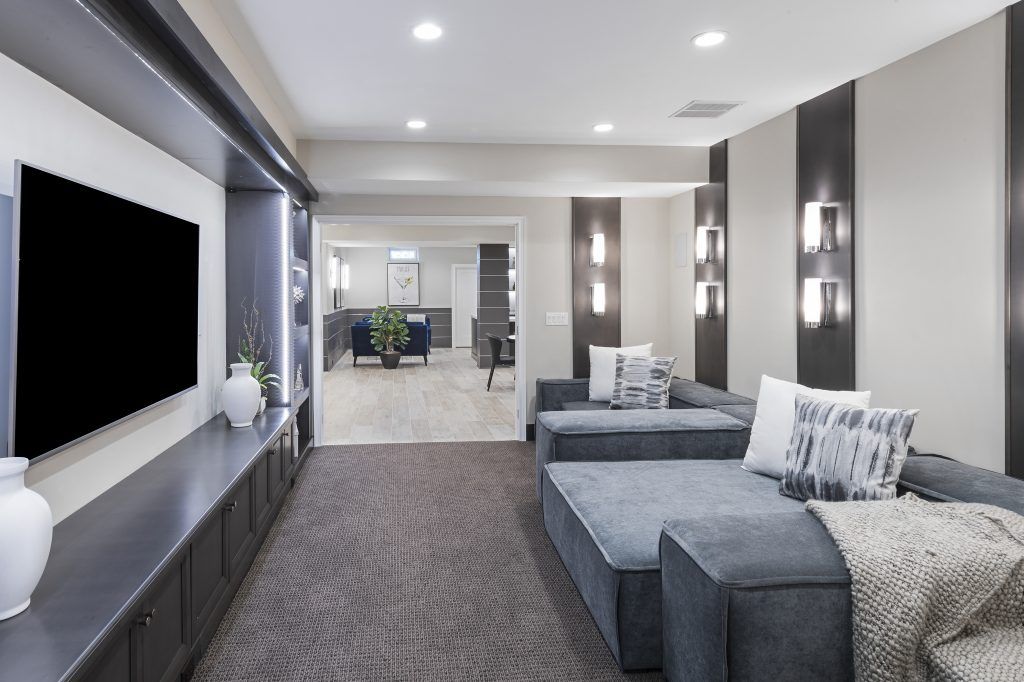 Modern living room with a gray sectional sofa, TV, and neutral-toned decor.