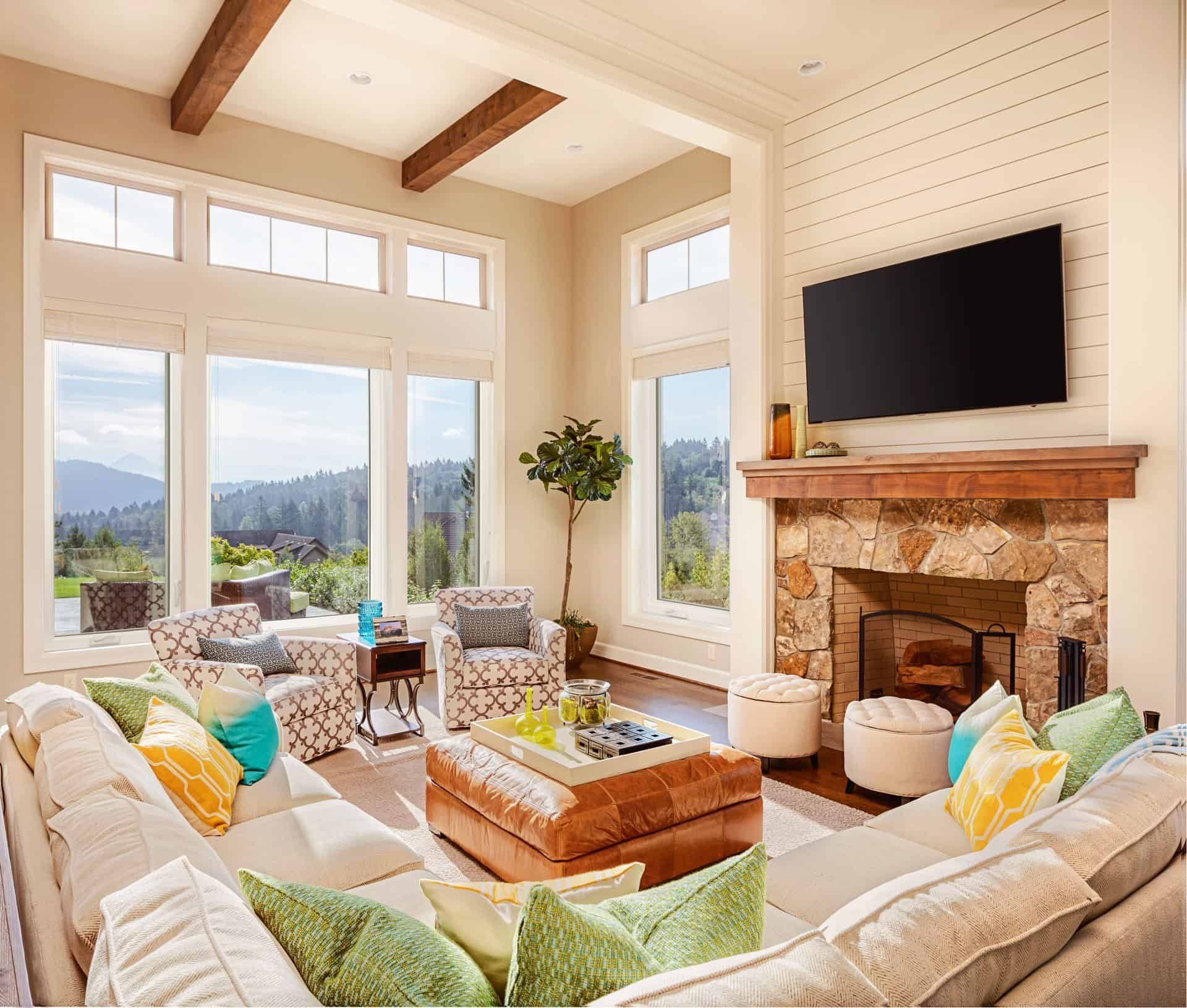 Living room with large windows, fireplace, sectional sofa, and mountain view.