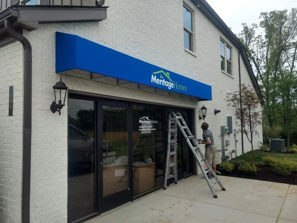 A worker climbs a ladder to install a blue 
