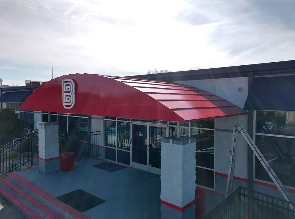 A red arched awning with a white letter 