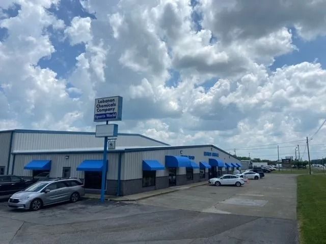 A one-story industrial building with blue awnings and a sign for 
