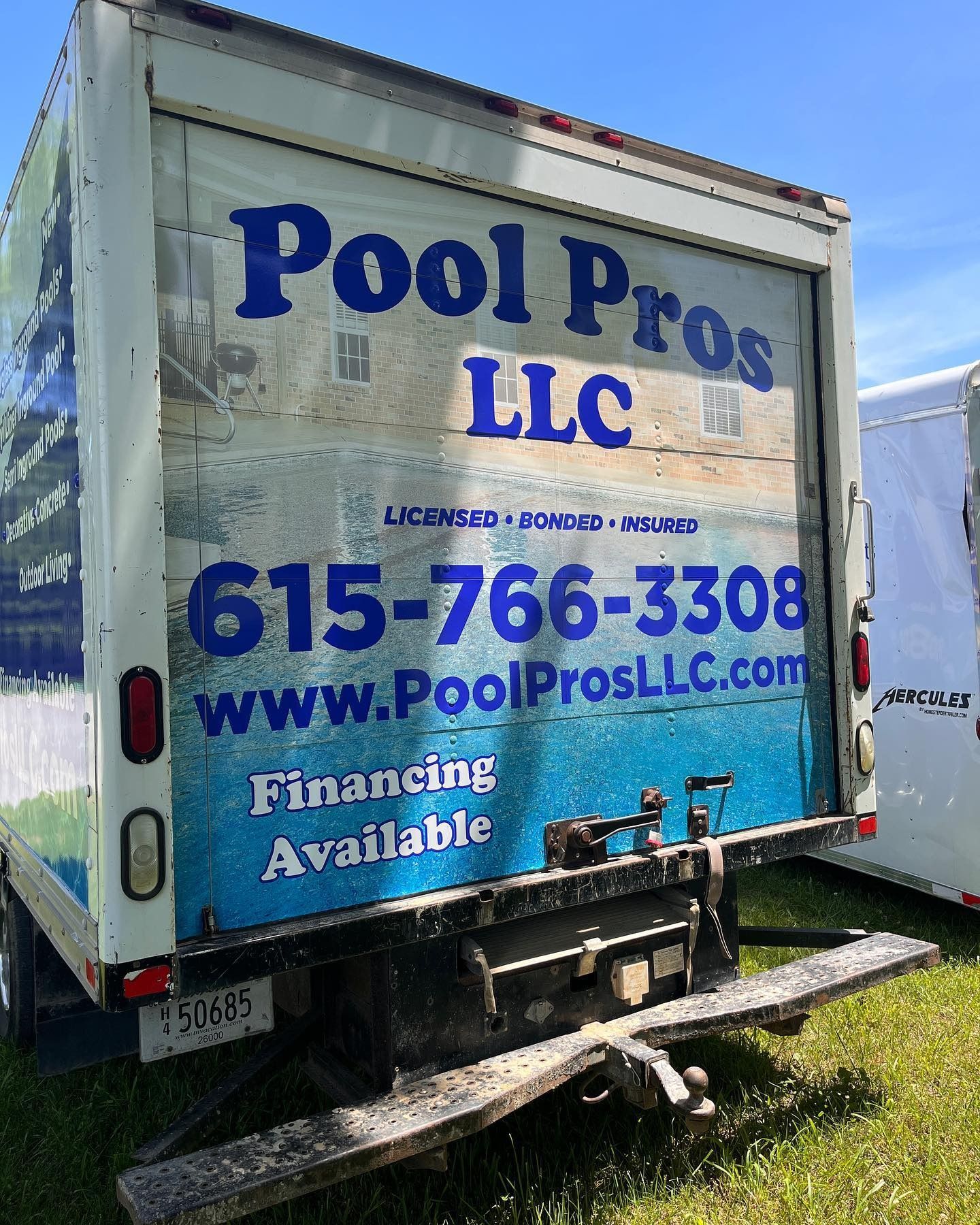 A Pool Pros LLC box truck with blue text, phone number, website, and 