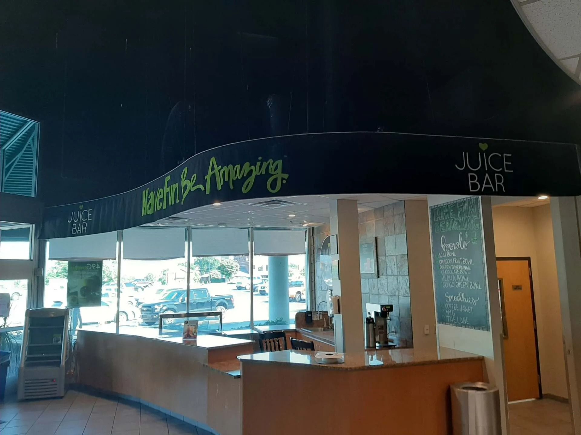 A curved juice bar counter with a black sign that says 