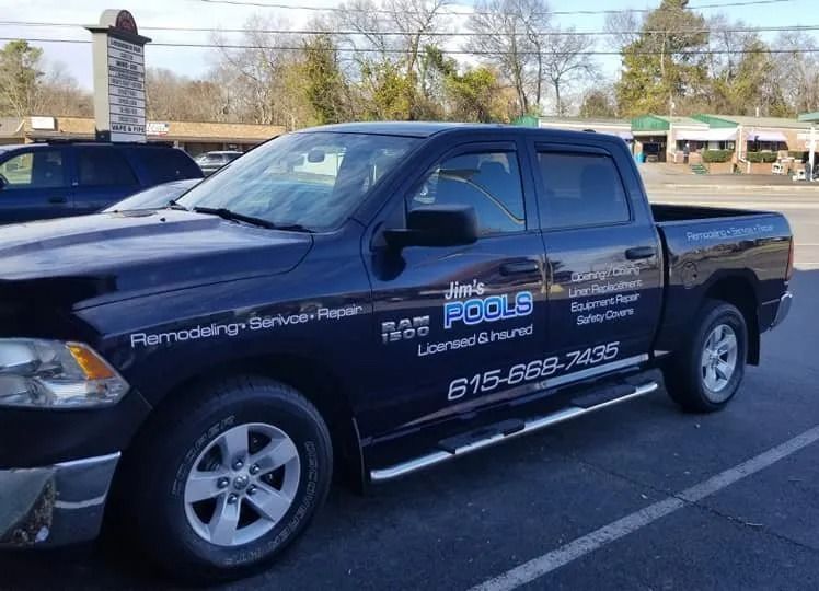 A dark blue Ram 1500 pickup truck parked in a lot, displaying 