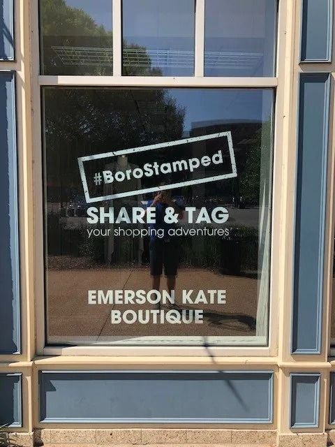 A store window displays a sign with 