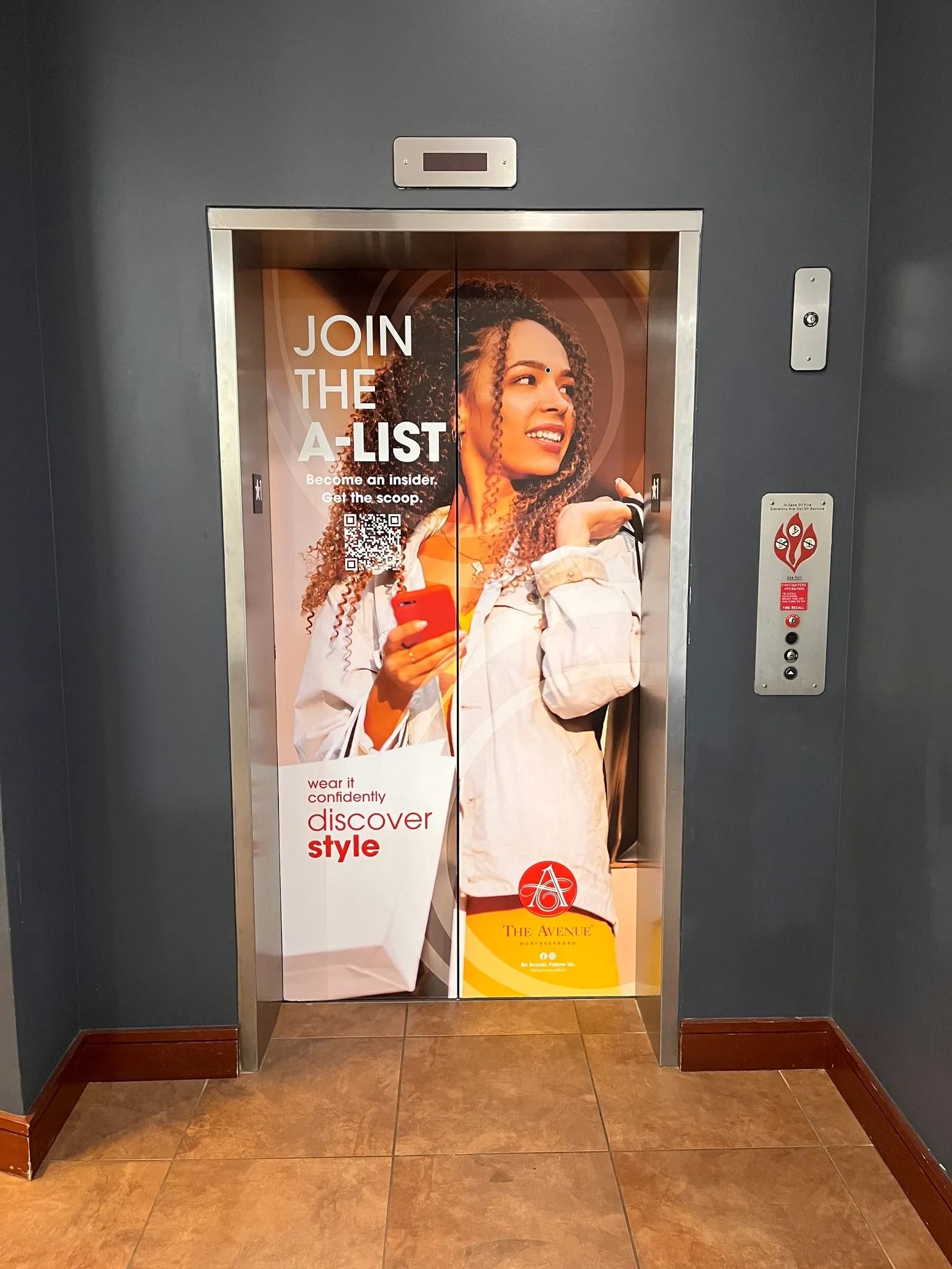 Elevator doors covered in a promotional advertisement for an 