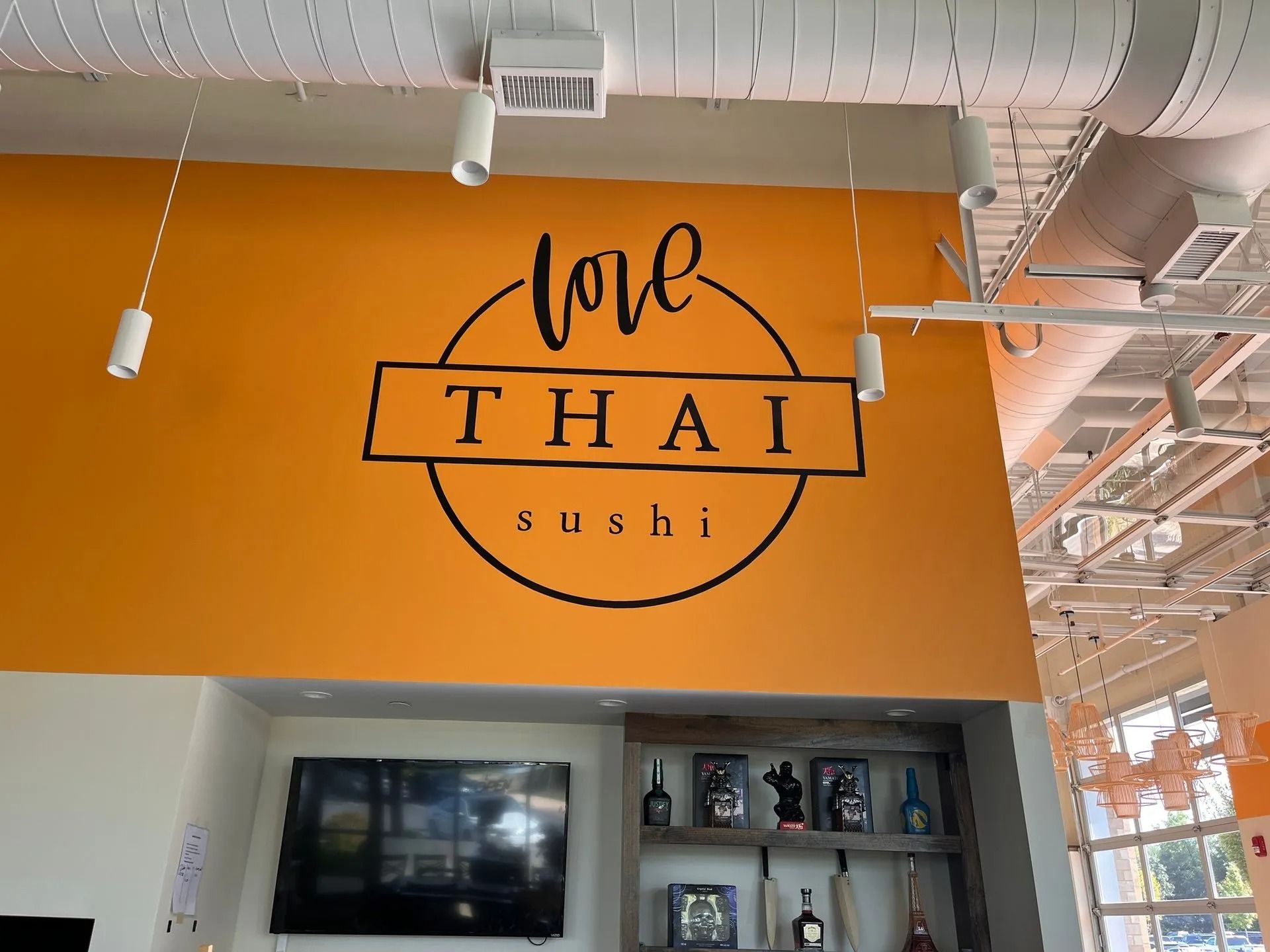A wall with an orange background featuring a black logo that says 