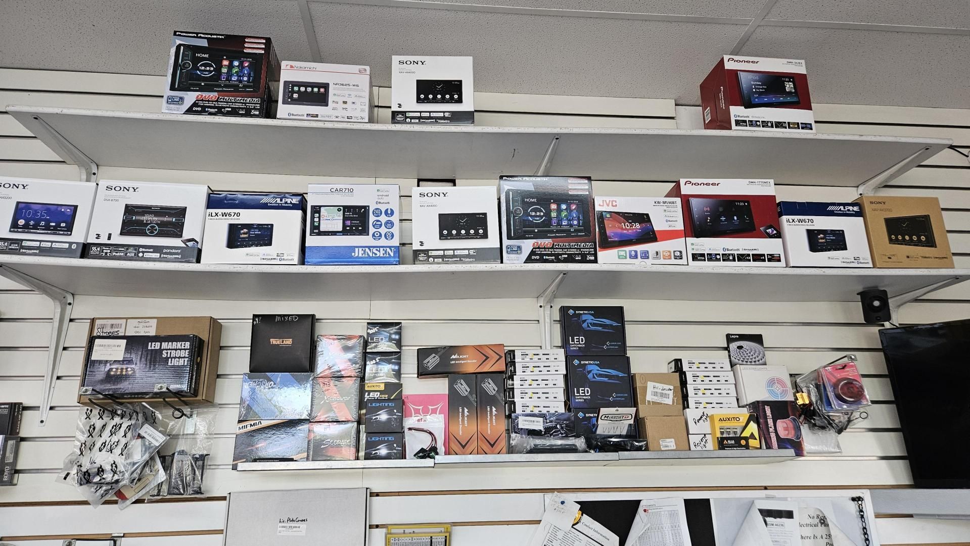 A shelf filled with a variety of car radios