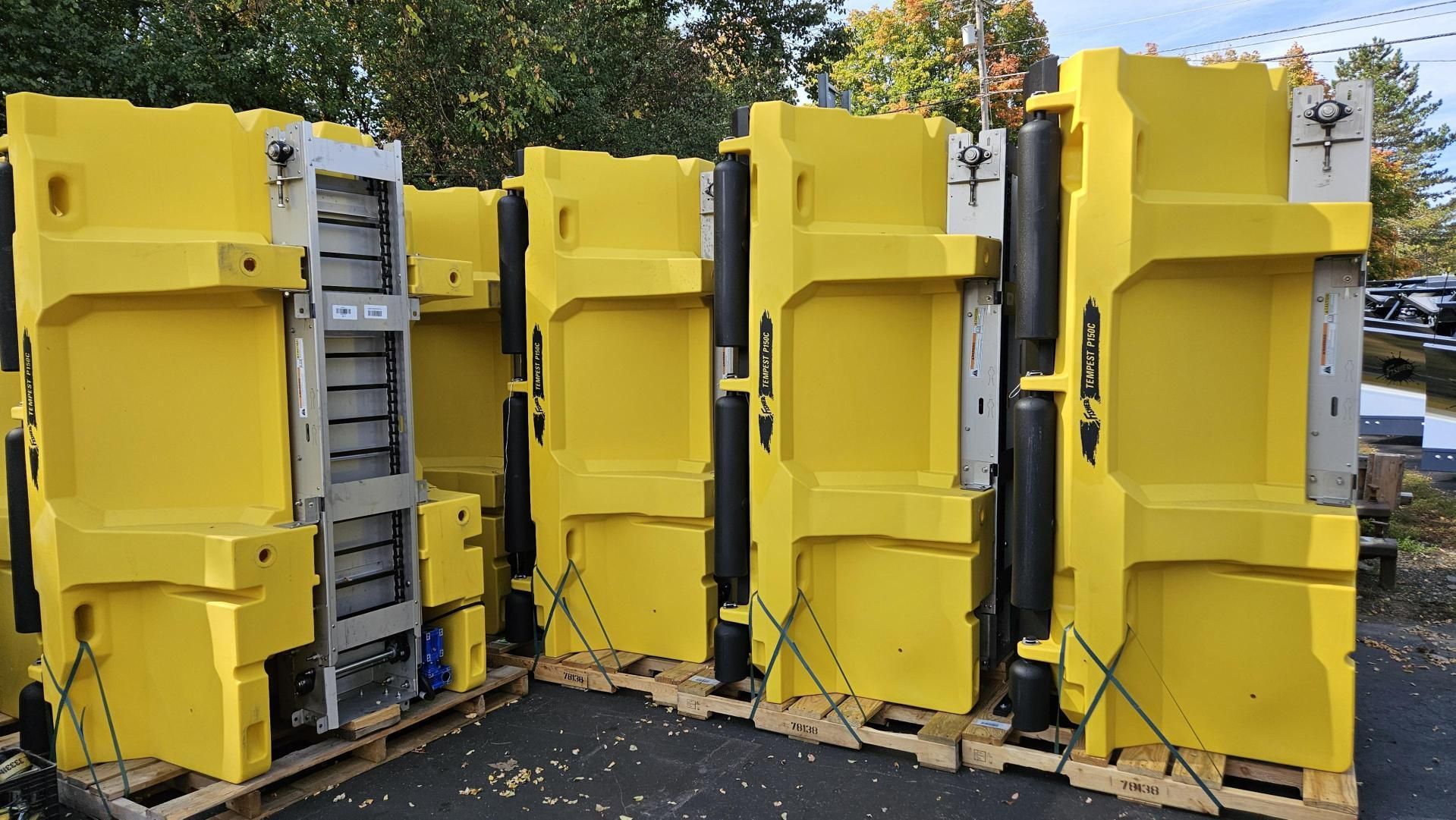 A row of yellow containers sitting on top of wooden pallets.