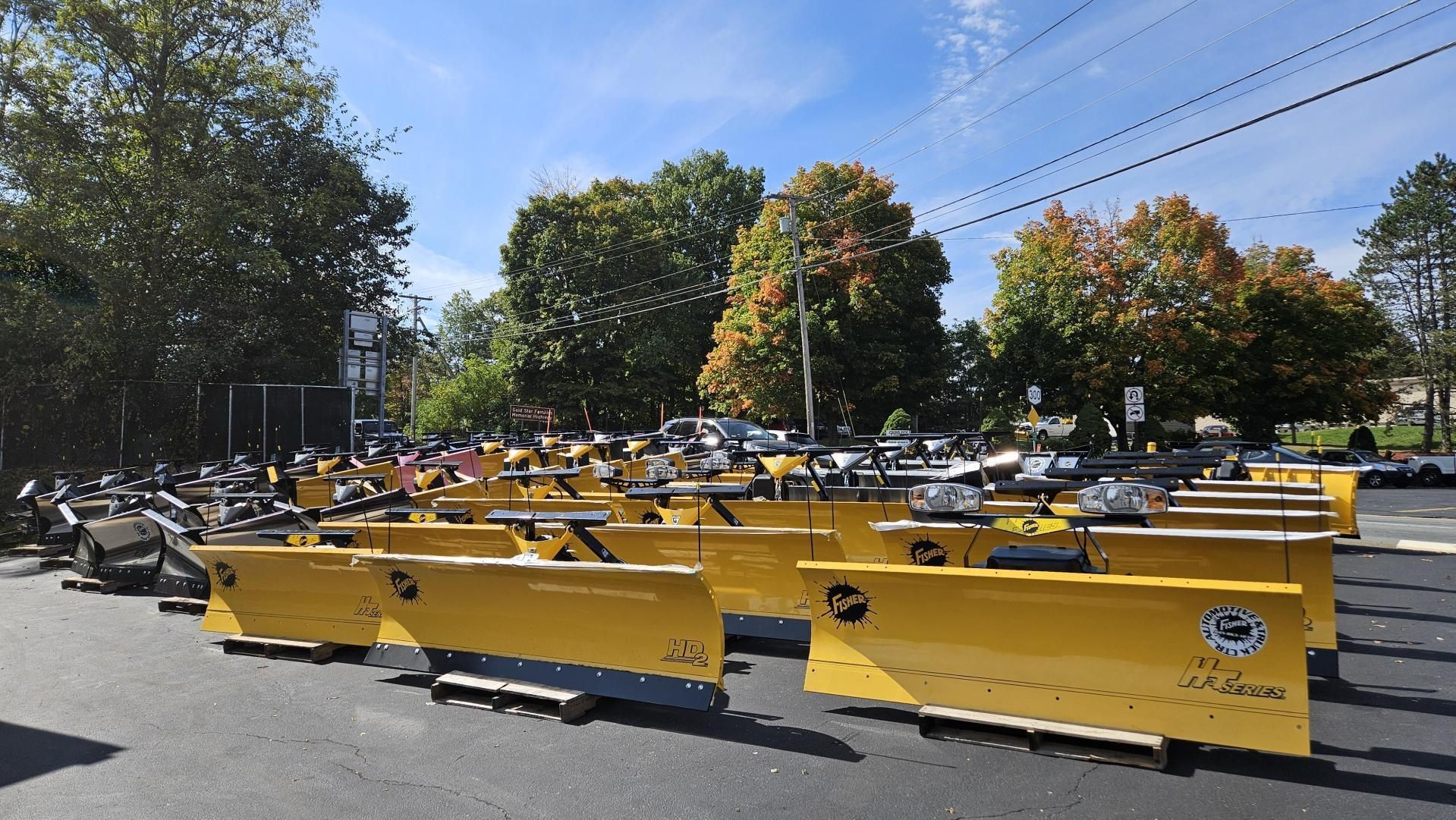 A bunch of yellow barriers are lined up in a parking lot