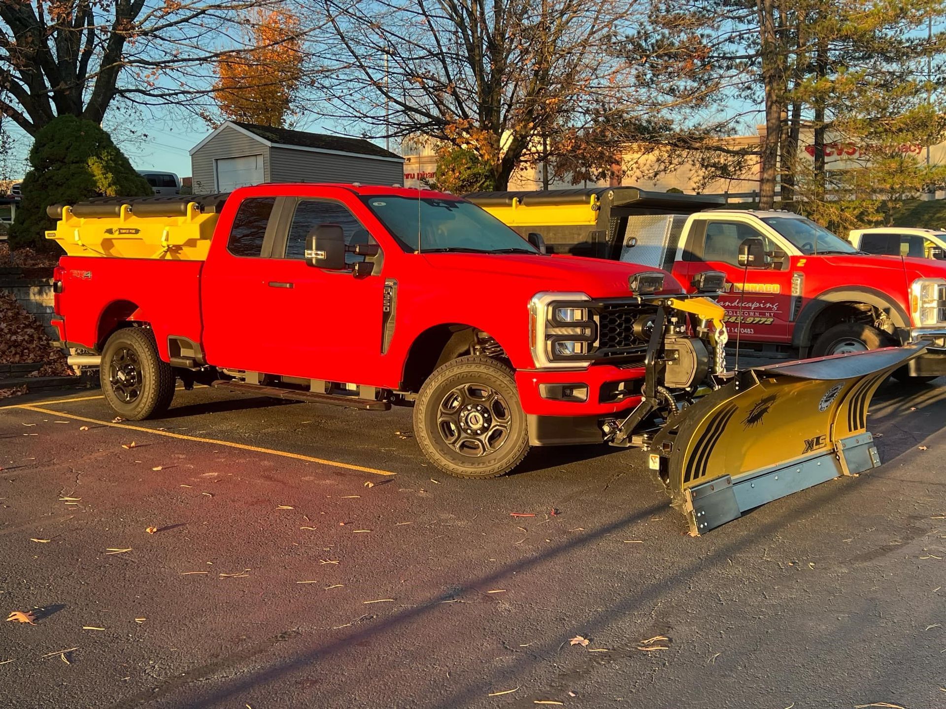 A red truck with a snow plow attached to it.