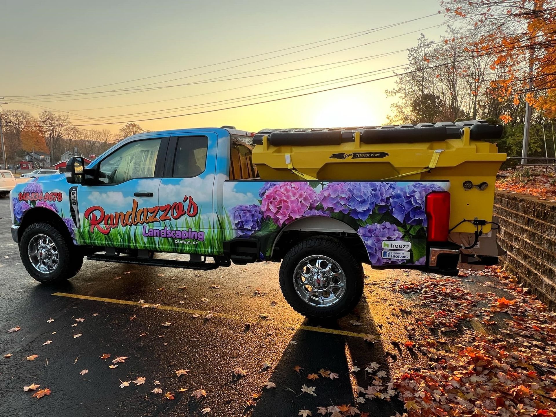 A truck with flowers painted on it is parked in a parking lot.
