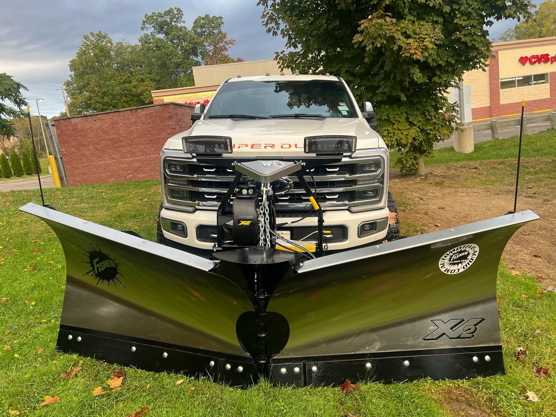 A white truck with a snow plow on the front of it.