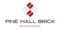 Logo for Pine Hall Brick with a red and gray geometric diamond brick pattern and the tagline