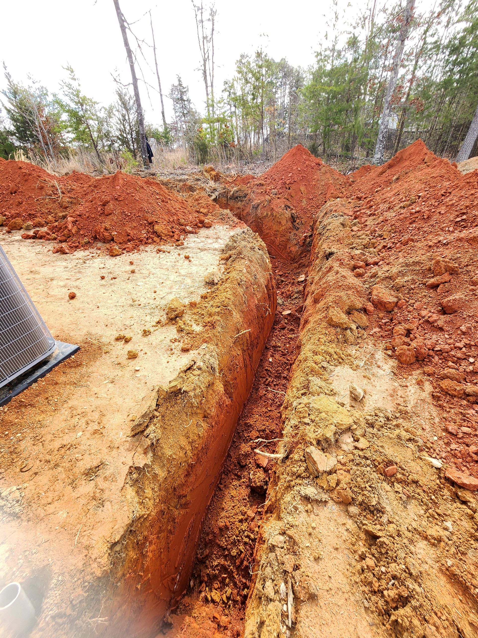 A person is digging a trench in the dirt.